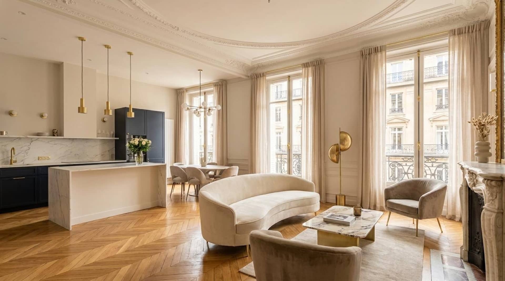 Séjour haussmannien ouvert sur une cuisine à îlot en marbre, parquet en point de Hongrie et cheminée en marbre
