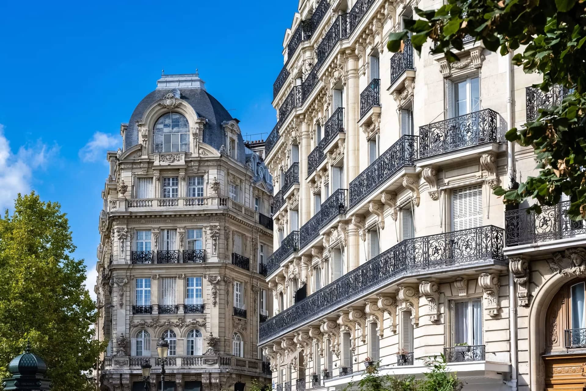 Immeubles haussmanniens en pierre de taille à balcons filants en fonte, immeuble d'angle à dôme d'ardoise