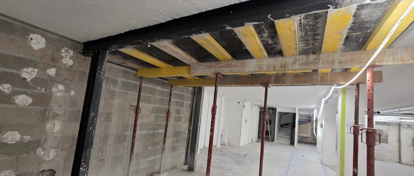 Sous-sol étayé sous la dalle en béton armé, poutre métallique posée avant la découpe de la trémie