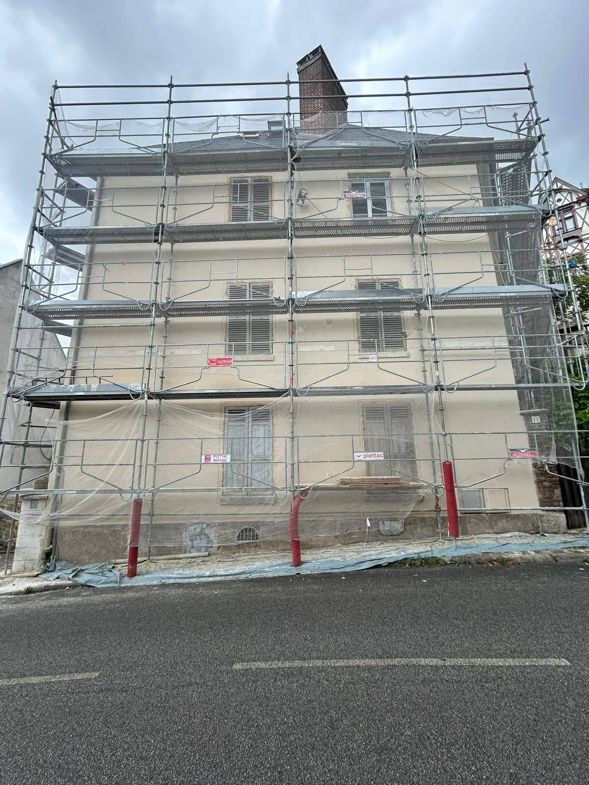 Immeuble ancien sous échafaudage pendant des travaux de façade, vu depuis la rue